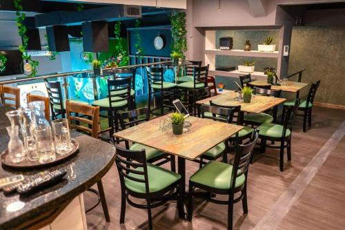 圣多明各Jardin Colonial Boutique Hotel的餐厅设有木桌和绿色椅子