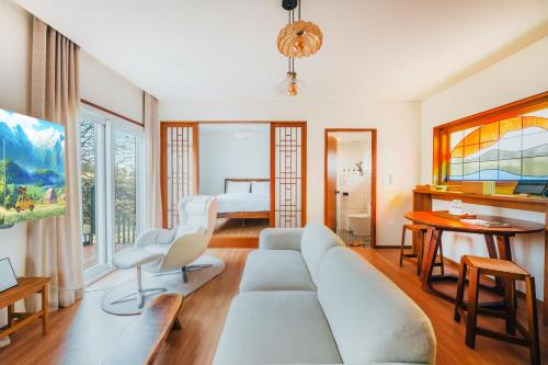 西归浦市Dazayo Hacheon Breeze House Pakeori - Pet friendely的客厅配有沙发和1张床