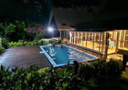 太平洋港Villa Serenity welcomes you的夜间在院子中间的游泳池