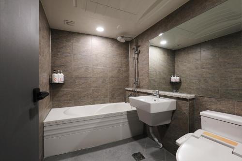 全州市Jeonju Urban Hotel的带浴缸、卫生间和盥洗盆的浴室