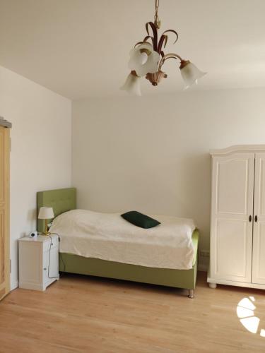 林斯托Inspektorenhaus Dobbin Ferienpension的一间卧室配有一张床和一个吊灯