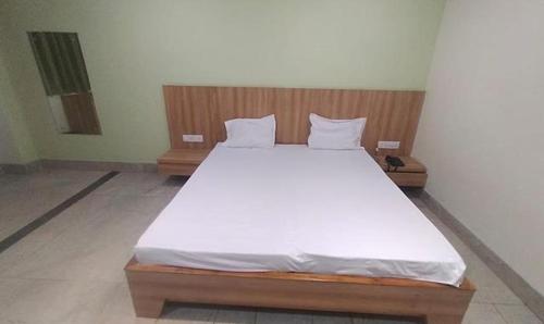 赖布尔FabHotel Park Mahindra的一间卧室配有一张带白色床单的大床