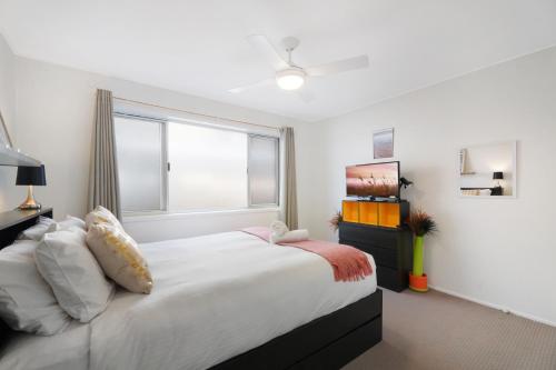 黄金海岸Two-bedroom Beachside Apartment with Parking的一间卧室设有一张大床和一个窗户。