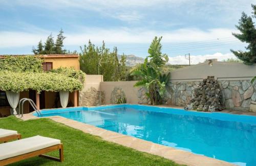 FoinikiáDM Elegant and Charming Villa的一座房子的院子内的游泳池