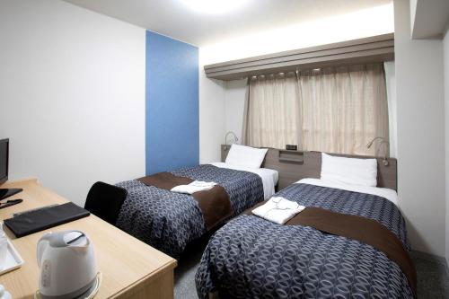 长崎长崎IK酒店的酒店客房设有三张床和一张书桌