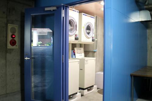 长崎长崎IK酒店的一间设有两台洗衣机的房间的蓝色门