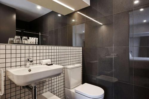 奥克兰Travelodge Hotel Auckland Wynyard Quarter的浴室配有卫生间、盥洗盆和淋浴。