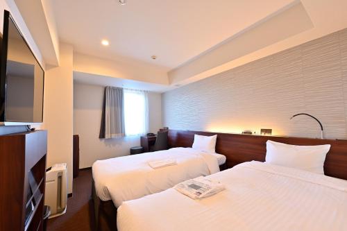 札幌札幌京阪酒店的酒店客房设有两张床和一台平面电视。