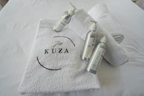 基利菲Kuza The Palm Villas at Vipingo的床上的2条免费毛巾和2瓶注射器