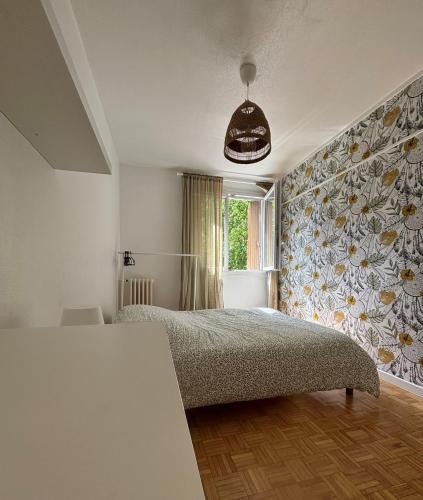 雷恩Appartement 3 chambres的一间卧室设有一张床和花卉墙