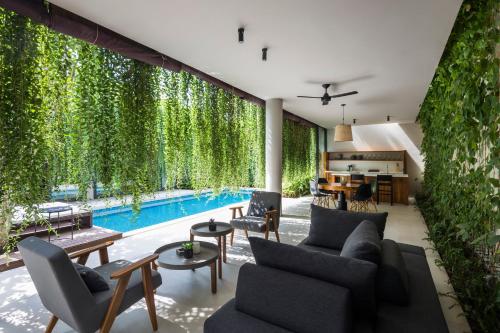 富国Villa Wyndham Phu Quoc的一间带游泳池和植物的客厅