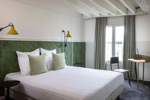 巴黎米娜酒店的酒店客房配有一张带白色枕头的大床