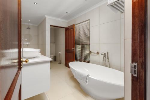 斯泰伦博斯Aaldering Luxury Lodges的白色的浴室设有浴缸和水槽。
