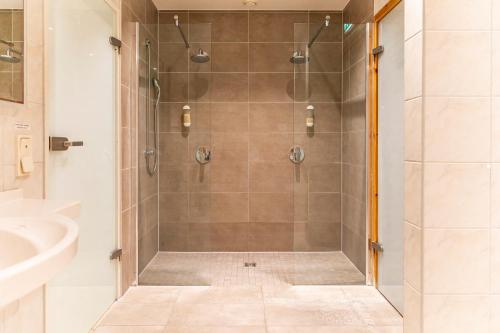 阿伦斯霍普摩根孙酒店的浴室里设有玻璃门淋浴