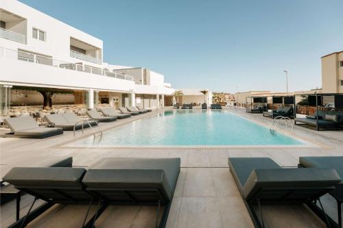 科斯塔卡玛R2 HIGOS BEACH的一个带躺椅的游泳池和一间酒店
