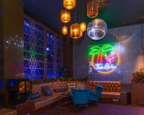 伦敦希尔顿伦敦塔桥酒店的一个带沙发和 ⁇ 虹灯标志的酒吧