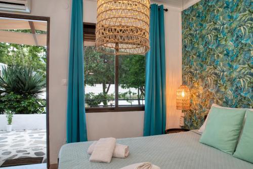 斯卡拉伯塔麦斯Ostria Hotel的一间卧室配有一张带吊灯和窗户的床。
