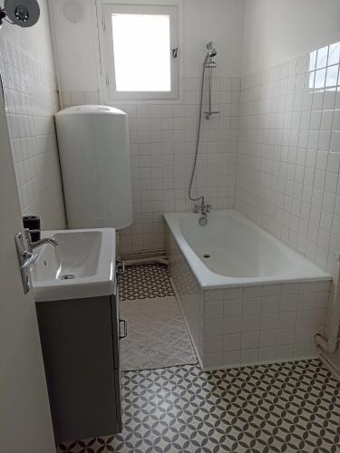 AuzancesAppartement Auzances的白色的浴室设有浴缸和水槽。
