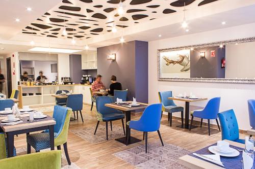 巴塞罗那圣家堂精品酒店的一间配备有桌子和蓝色椅子的用餐室