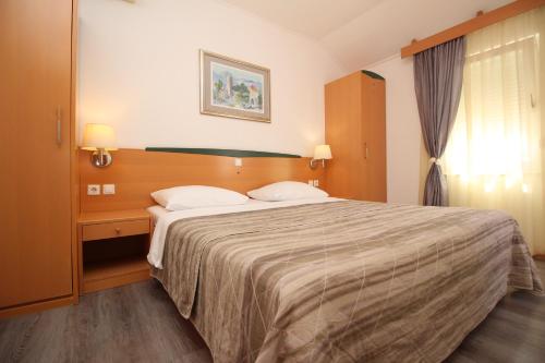 巴斯卡Villas Corinthia的一间卧室配有一张大床和两个枕头