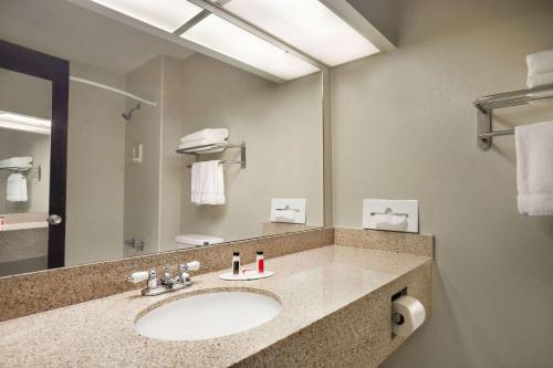 堪萨斯城Baymont by Wyndham Kansas City KU Medical Center的一间带水槽和大镜子的浴室