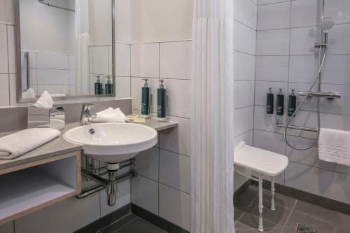 埃文河畔斯特拉特福英国埃文河畔斯特拉特福希尔顿逸林酒店的白色的浴室设有水槽和淋浴。