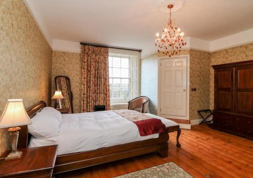 阿比莱克斯Preston House的一间卧室配有一张床、一张桌子和一个吊灯。