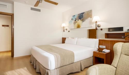 巴塞罗那Ilunion Les Corts Spa的酒店客房,配有一张床和两把椅子