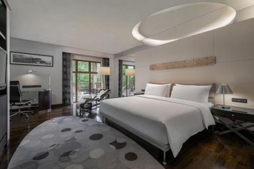 厦门厦门艾美酒店（位于城市公园之中，森林氧吧）的卧室配有一张白色大床和一张书桌