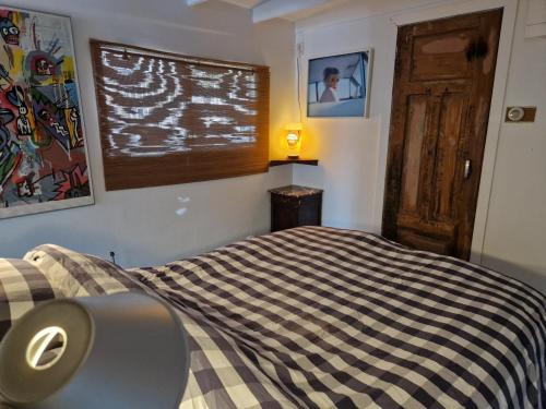 阿姆斯特丹顶楼船屋的一间卧室配有一张带黑白毯子的床