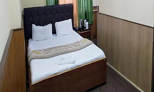 甘托克FabHotel Palbhu的一间卧室配有一张大床和黑色床头板
