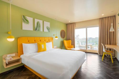 帕纳吉Bloom Hotel - Dona Paula的酒店客房设有一张大床和一张书桌。