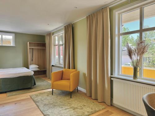 摩尔比兰加Hotell Magasin 1的卧室配有床、椅子和窗户。