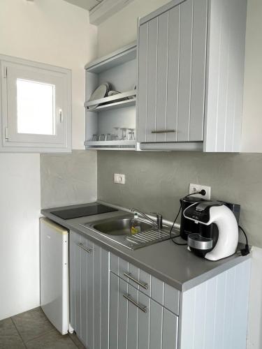 ManganariMAGGANARI MOMENTS 2的厨房配有白色橱柜和水槽