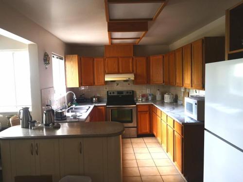 温哥华溫西Ubc如悅民宿的厨房配有木制橱柜和白色冰箱。