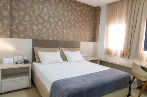 阿拉瓜伊纳Brii Hotel的卧室设有一张白色大床和一扇窗户。