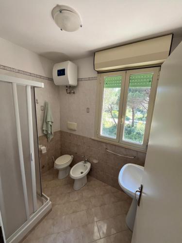 普林希匹纳马尔Residence Verde Pineta的浴室设有2个卫生间、水槽和窗户。