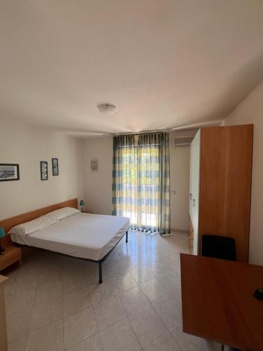 普林希匹纳马尔Residence Verde Pineta的一间卧室设有一张床和一个大窗户