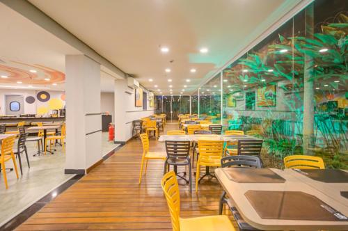 圣保罗Transamerica Fit Villa Lobos的一间带桌椅和壁画的餐厅