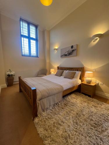 温莎Victorian convent的一间卧室设有床、窗户和地毯。