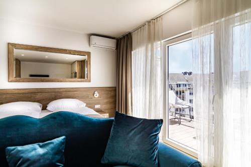 杜塞尔多夫Sleep Inn Düsseldorf的一间卧室配有蓝色的沙发、一张床和一个窗户。