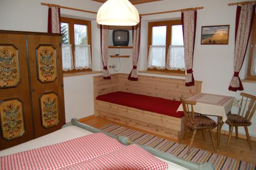 塔克森巴赫Großberghof的一间卧室配有一张床、一张桌子和一台电视。