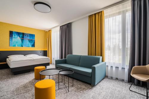 赫拉德茨 - 克拉洛韦EA Congress Hotel Aldis的酒店客房设有床、沙发和桌子。
