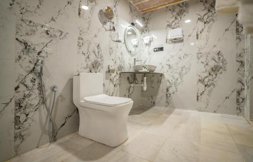 斋沙默尔Desert Heritage Luxury Camp And Resort的浴室设有白色卫生间和黑白墙纸。