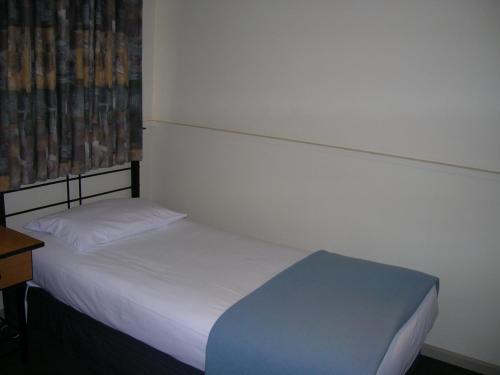 谢珀顿奥弗兰德酒店汽车旅馆 的一间小卧室,配有一张床和一张书桌