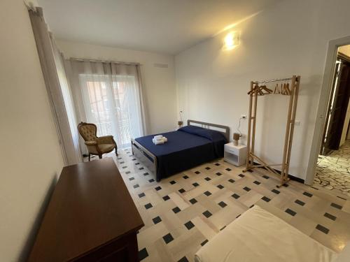 阿拉西奥Airaldi8 -Ex La Reggia- Trilocali in centro a 50 m dal mare的一间卧室配有蓝色的床和椅子