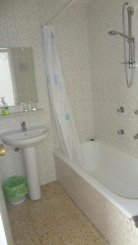 多列毛利诺斯Hotel Carlos I的浴室配有盥洗盆、浴缸和盥洗盆