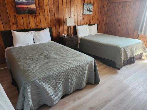 Aulds CoveThe Cove Motel & Restaurant的配有木墙和木地板的客房中的两张床
