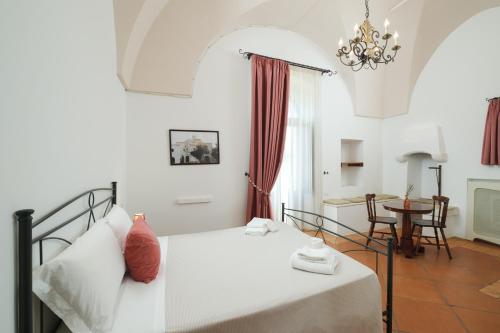 奥斯图尼Borgo Santuri的卧室配有白色的床和桌子