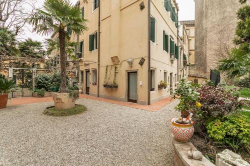 威尼斯Cinqueteste Luxury Home的种有盆栽植物的庭院和一座建筑